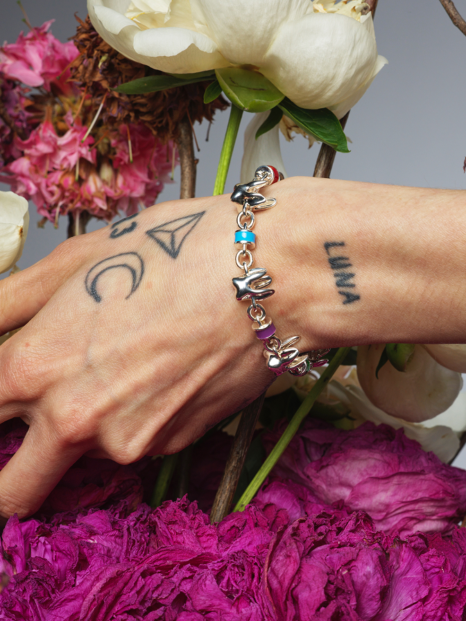 Hand wearing ALF Jewelry sterling silver bracelet with colorful enamel details, luxury handcrafted design.
